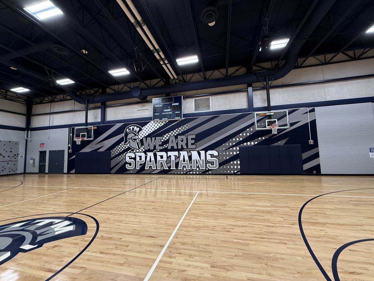 Wall wrap deportivo en gimnasio escolar con gráfica Spartans