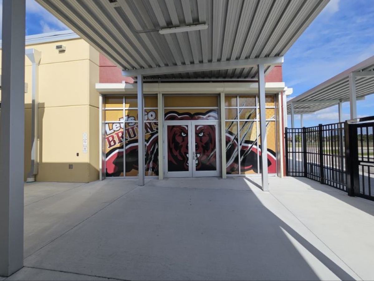 Entrada comercial con gráfica microperforada en ventanales y puertas